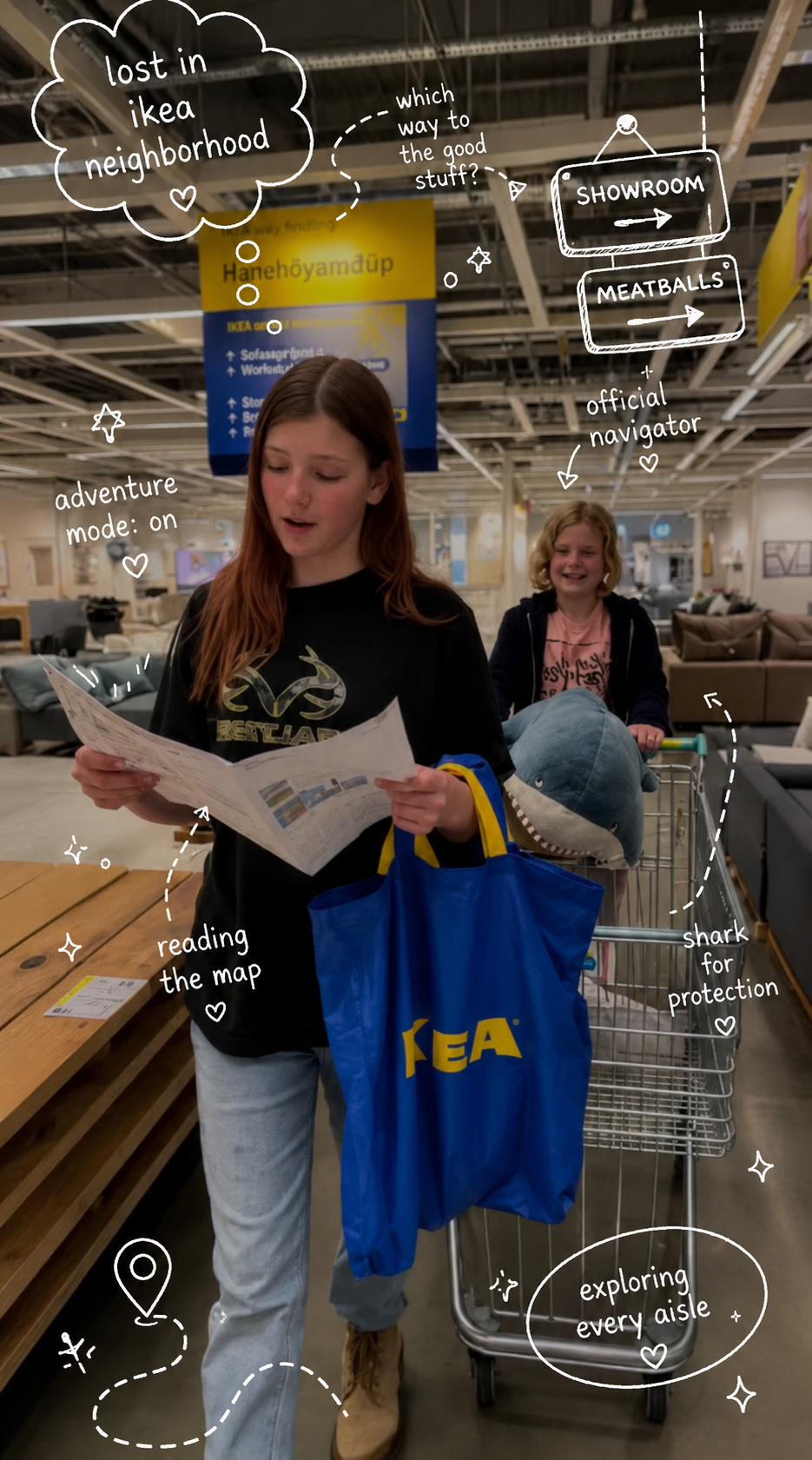 Ruby reading the Ikea map while Maple pushes the cart with a shark plushie